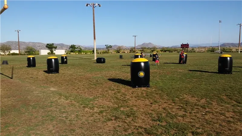 Triple O inflatable laser tag bunkers spread across a large grass field with players in vests